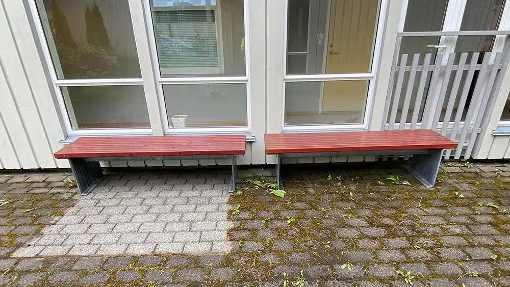 Benker langs vegg og uteareal som vaskes